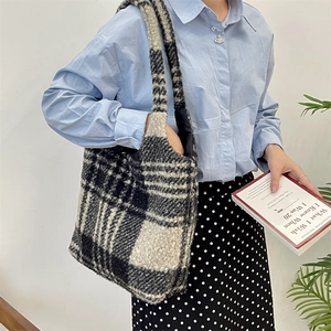 Close-up of plush black and white checkered tote bag showing curly boucle wool texture