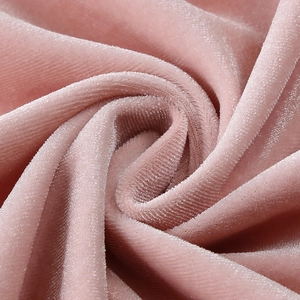 Macro shot of soft pink velvet fabric texture with luxurious glossy sheen and drapery