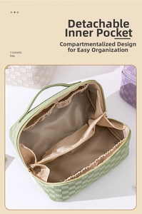 Detail view of mint green cosmetic bag with interior divider and embossed texture