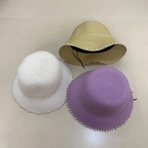 Close-up of woven straw sun hats with elegant pearl trim in white, khaki and purple