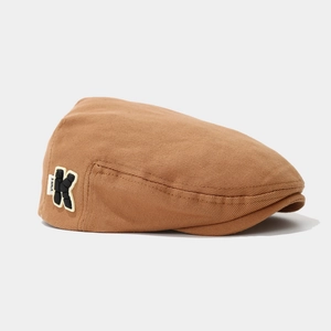 Detail of camel beret showing twill fabric texture and black letter K applique