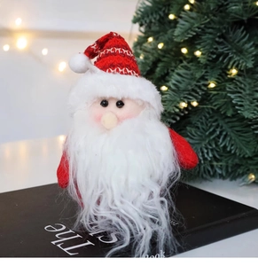 Detailed close-up of a Santa plush ornament with a red knitted hat on a festive background