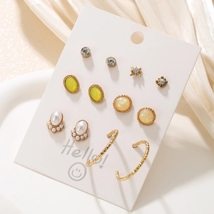 Detail view of 12-piece gold-tone earring set with pearls and gems on white card