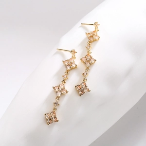 Elegant 18K gold plated tassel earrings with champagne cubic zirconia on white stand