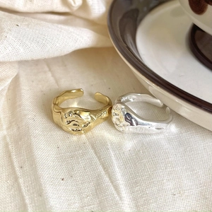 Macro shot of irregular lava texture gold and silver 925 sterling silver open rings