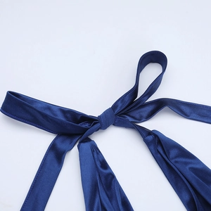 Close-up detail of a navy blue satin bow on the off-shoulder strapless A-line dress