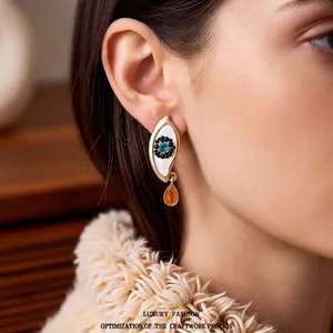 Vintage evil eye drop earrings with blue crystal and yellow gemstone on model
