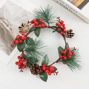 Christmas wreath with red berries, pine needles and cones on white decorative background
