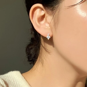 Detail view of 925 sterling silver square zircon stud earrings worn by a model