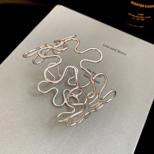 Detail view of silver hollow wave open cuff bracelet with polished metallic finish