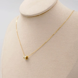 Minimalist gold titanium steel necklace featuring a sparkling crystal cylinder pendant