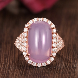 Macro shot of rose gold ring with oval purple gemstone and sparkling diamond halo