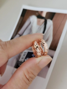 Close-up of S925 silver hoop earrings in rose gold with molten lava textured surface