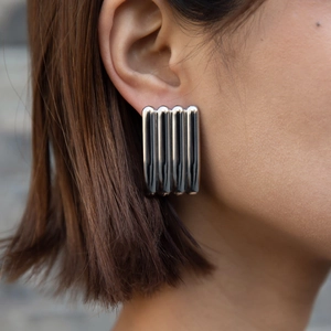 Silver rectangle ribbed stainless steel earrings shown on model in a modern style