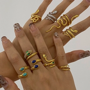 Adjustable snake rings in gold and silver finish with gemstones on female hand