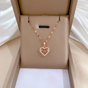 Rose gold heart pendant necklace with shimmering crystals in a beige jewelry gift box