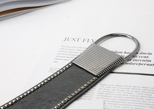 Detail of a black punk waist belt with silver oval buckle and metal studs on magazine