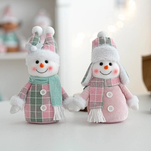 Close-up of plush Christmas snowmen figurines in green and pink plaid holiday outfits