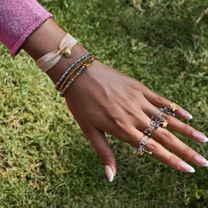 Bohemian style jewelry set with beaded bracelets and gold star rings on grass
