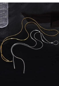 Detail of adjustable gold and silver snake bone necklaces with reflective mirror finish