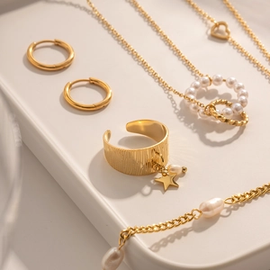 Detail of 18K gold star pendant open ring with matching pearl jewelry set display