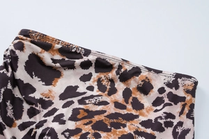 Detailed macro view of leopard print fabric with precise stitching and silky texture
