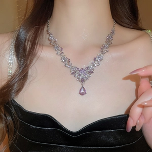 Detail of silver floral necklace with purple pear-cut rhinestones on model neck