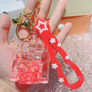 Detailed close-up of a castle-shaped liquid keychain with red sequins and star lanyard