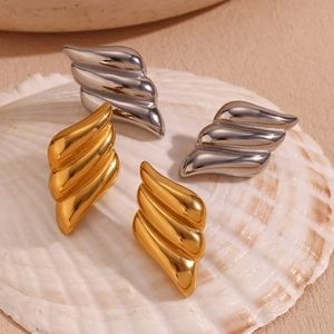 Macro detail of geometric triple-layer wing earrings in 18K gold and silver plating