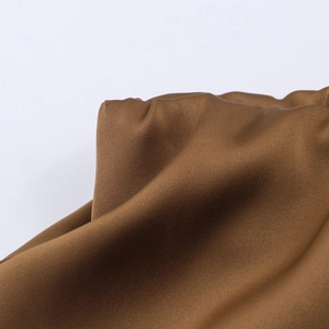 Detail of premium brown satin skirt fabric showing smooth texture and elegant drape