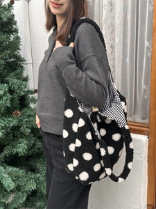 Photo de style d'un sac seau en peluche à pois blancs et noirs au look hivernal douillet