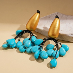 Detail view of Bohemian tassel earrings with gold-tone metal and turquoise stones