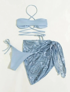 Detailed flat lay of light blue three-piece bikini set with marble print mesh sarong skirt
