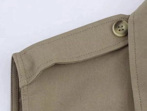 Dettaglio dell'abito corto kaki in twill con spalline decorative e bottoni rifiniti