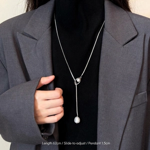 Elegant Y-shaped zircon necklace with adjustable slider and twin pearl charms on black sweater