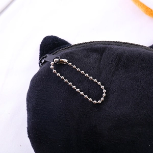 Detailed macro view of black plush cat-eared coin purse with silver metal zipper closure