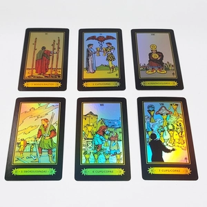 Detail of laser foil tarot cards with golden borders and bilingual labels on white background