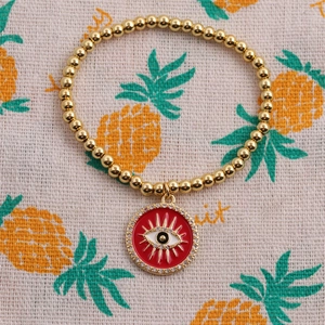 Bracelet à perles dorées avec un pendentif œil protecteur rouge orné de zircons brillants