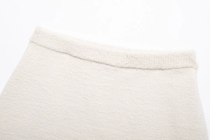 Detaillierte Makroansicht des cremeweißen Tweed-Rocks mit Fokus auf die Webstruktur