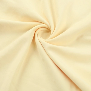 Gros plan détaillé d'un tissu en maille crème montrant texture douce et drapé élégant