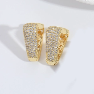 Dettaglio di orecchini a cerchio a V dorati con micro-pavé di cristalli di zircone bianchi
