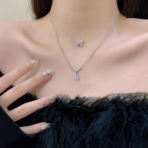 Close-up of double-layer butterfly choker and teardrop pendant on a model's neck