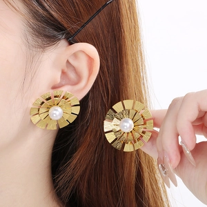 Vue détaillée des boucles d'oreilles pétales en or vintage avec perle blanche centrale