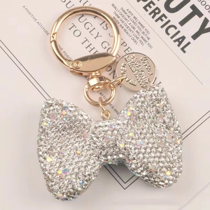 Dettaglio del portachiavi a fiocco con strass scintillanti e chiusura in oro chiaro