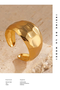 Macro detail of 18K gold plated hammered texture open ring on a stone background