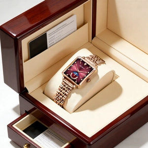 Detailed view of luxury square rose gold watch with red sun-moon dial in wooden gift box