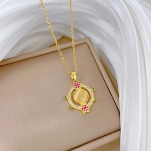 Close-up of gold pendant necklace with cat eye stone and multi-colored gemstones