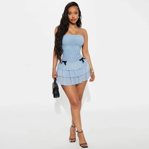 Détail de la robe bustier à pois bleu clair avec maille superposée et nœuds noirs