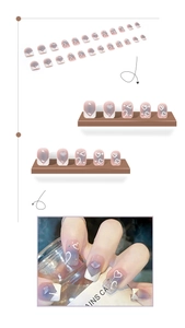 Macro view of lavender and white gradient press-on nails with heart and rhinestone accents