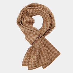 Detail of knit scarf featuring brown and white checkered diamond pattern texture